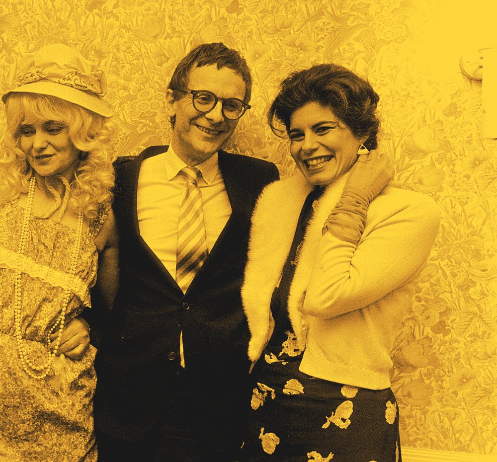 Willem de Ridder lacht, met zijn armen om twee vrouwen van het programma Portable Vaudeville, Holland Festival 1983.